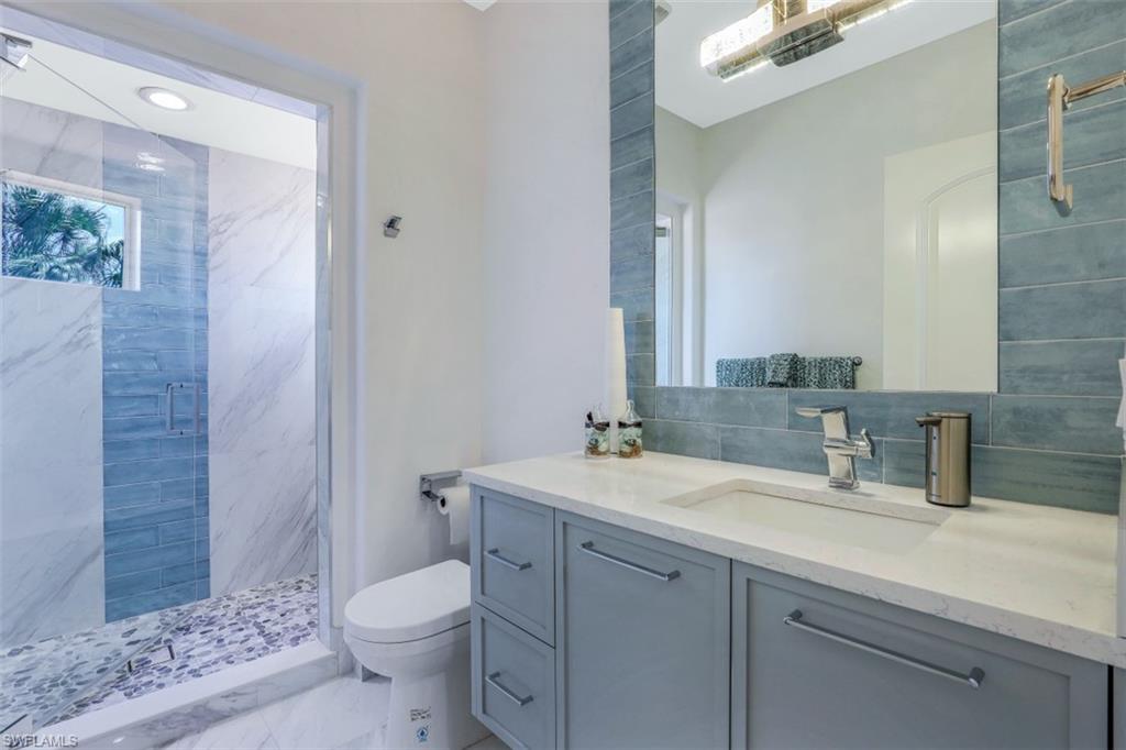 16683 Lucarno Way Naples, FL 34110 - Photo 24 of 35 a bathroom with a sink a toilet a shower and a mirror