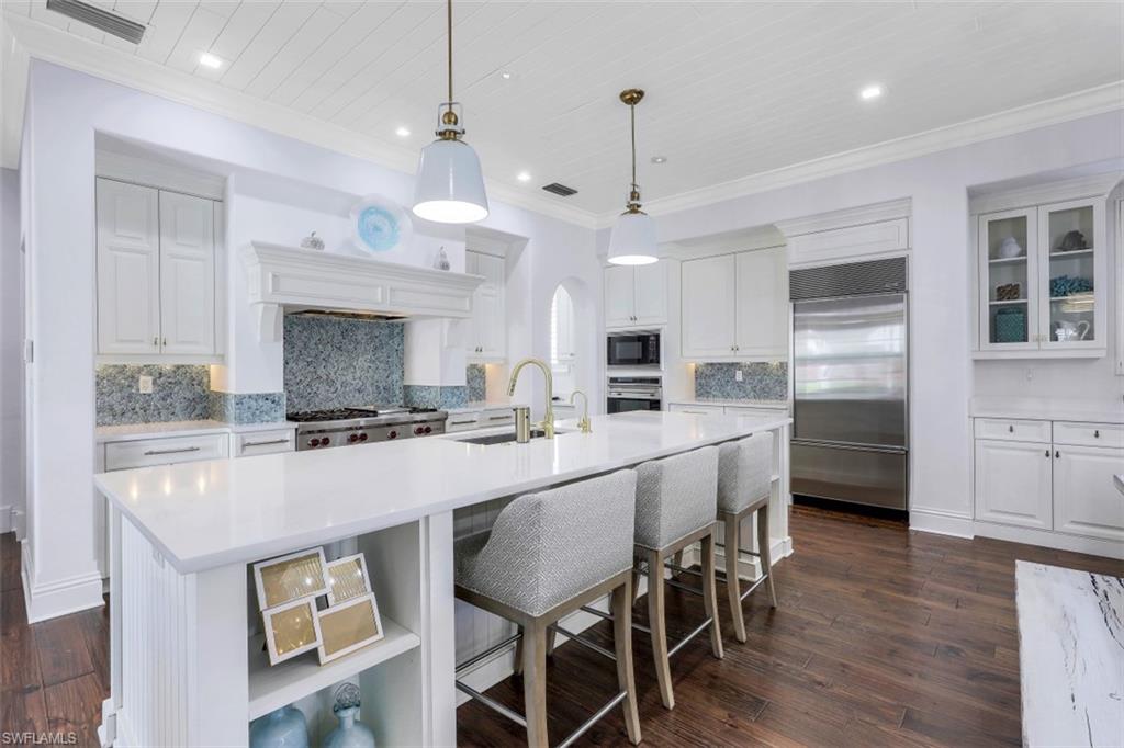 16683 Lucarno Way Naples, FL 34110 - Photo 10 of 35 a room with stainless steel appliances kitchen island a table and chairs in it