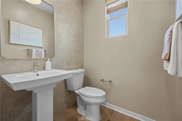 a bathroom with a toilet a sink and mirror