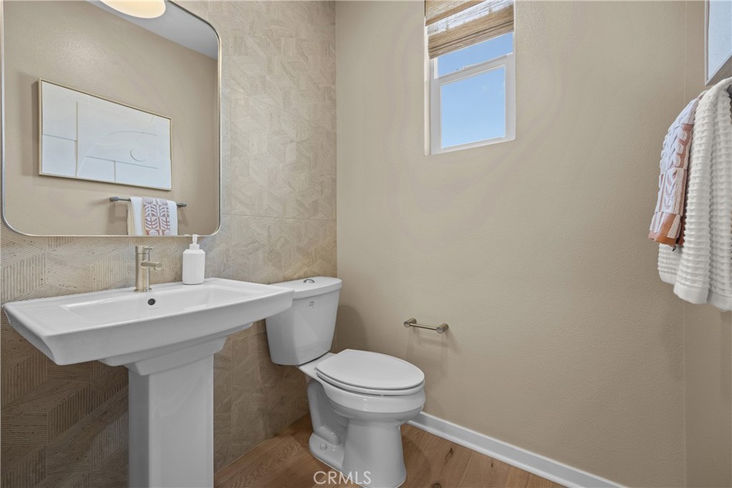 7373 Suva Street Downey, CA 90240 - Photo 12 of 14 a bathroom with a toilet a sink and mirror