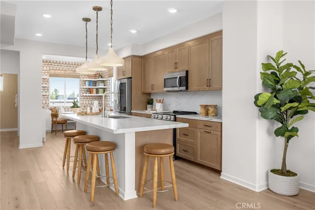 a kitchen with stainless steel appliances a table and chairs in it