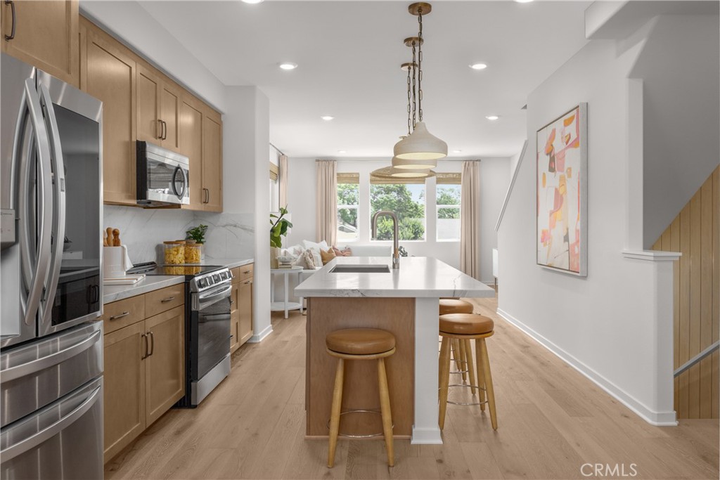 7373 Suva Street Downey, CA 90240 - Photo 5 of 14 a kitchen with stainless steel appliances granite countertop wooden cabinets a sink stove and refrigerator