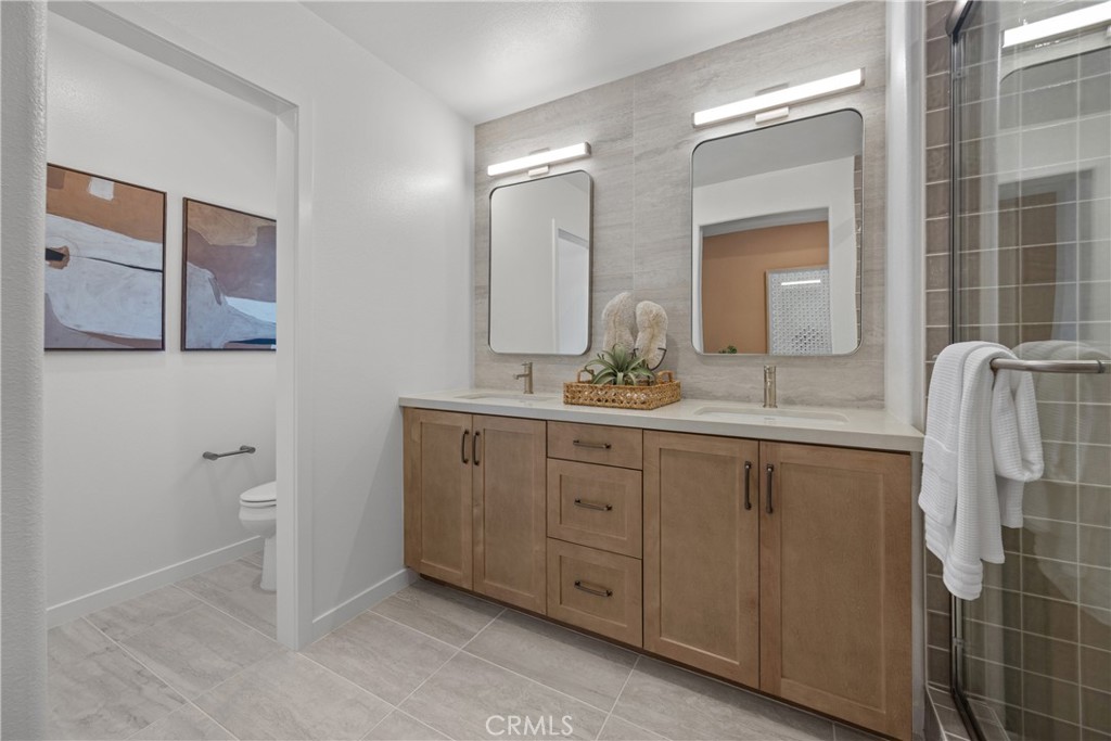7373 Suva Street Downey, CA 90240 - Photo 7 of 14 a spacious bathroom with a double vanity sink and a mirror