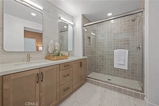 a bathroom with a double vanity sink toilet and shower