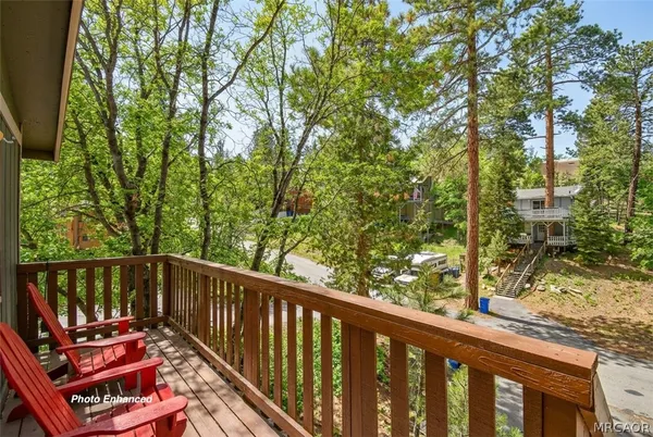 a view of a balcony with wooden floor and fence