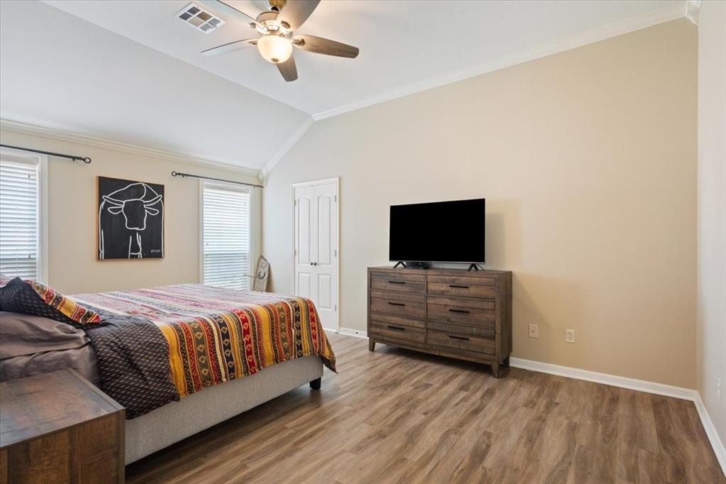 203 Silver Spur Trail Waco, TX 76657 - Photo 16 of 39 Bedroom with crown molding, wood finished floors, lofted ceiling, and a ceiling fan
