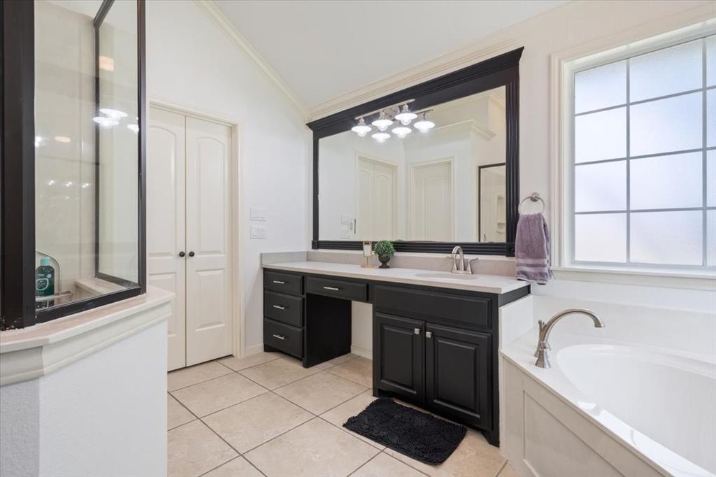 203 Silver Spur Trail Waco, TX 76657 - Photo 17 of 39 Full bath with vanity, a bath, crown molding, tile patterned flooring, and lofted ceiling