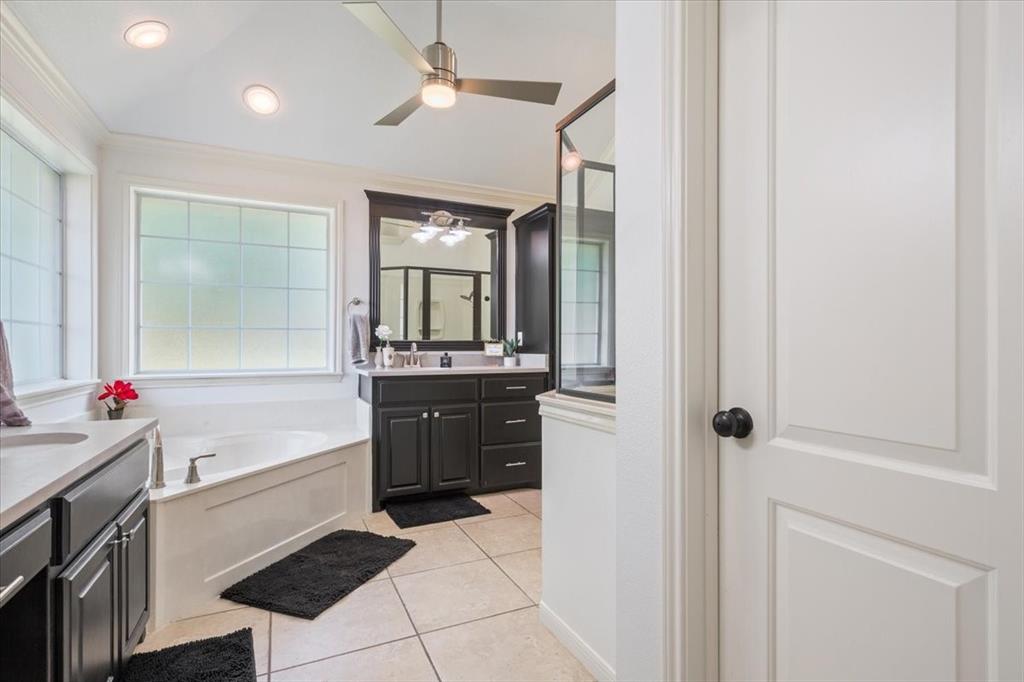 203 Silver Spur Trail Waco, TX 76657 - Photo 19 of 39 Full bath featuring tile patterned floors, a bath, two vanities, crown molding, and a ceiling fan