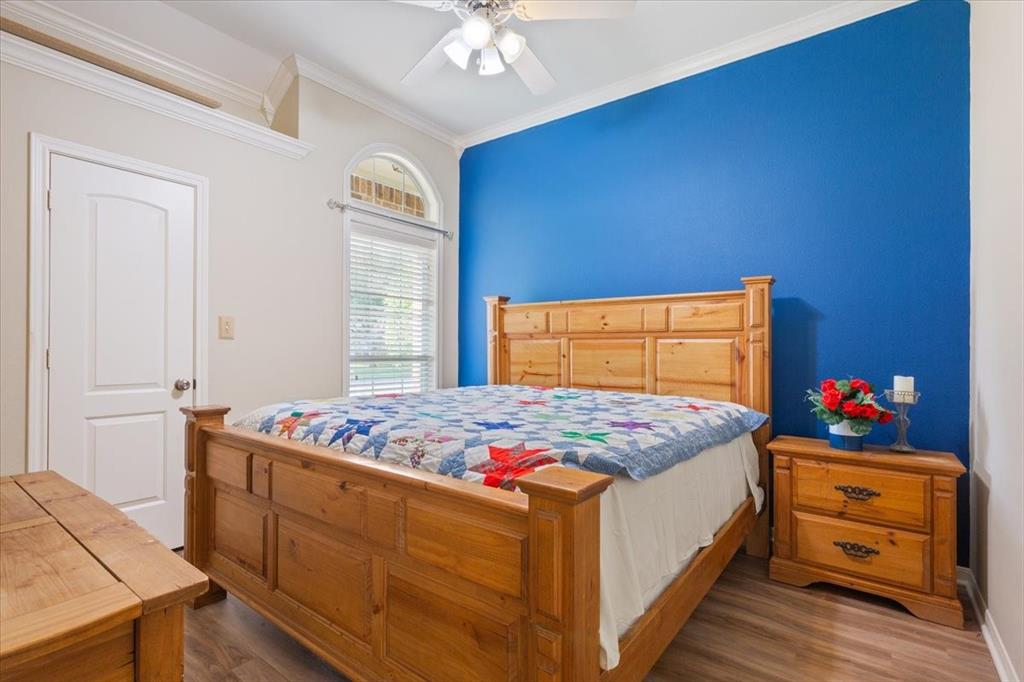 203 Silver Spur Trail Waco, TX 76657 - Photo 23 of 39 Bedroom featuring crown molding, wood finished floors, and a ceiling fan