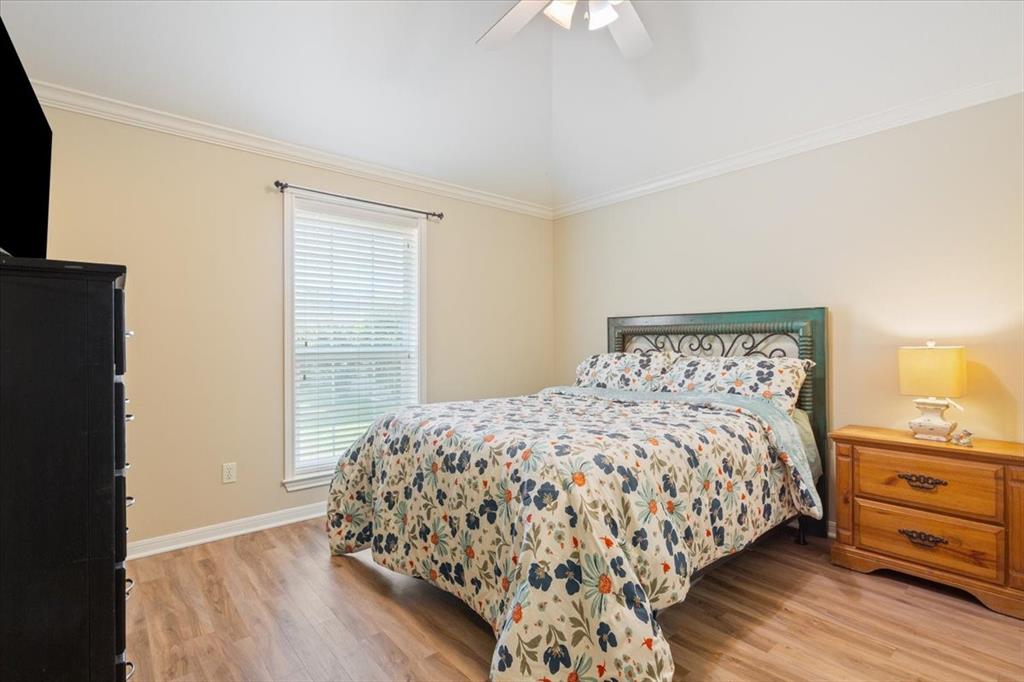 203 Silver Spur Trail Waco, TX 76657 - Photo 24 of 39 Bedroom featuring crown molding, light wood-style floors, and a ceiling fan