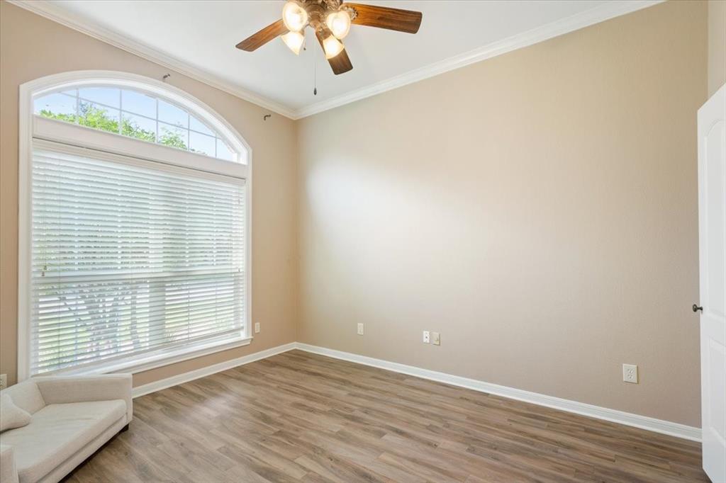 203 Silver Spur Trail Waco, TX 76657 - Photo 5 of 39 Unfurnished room featuring ornamental molding, wood finished floors, and a ceiling fan