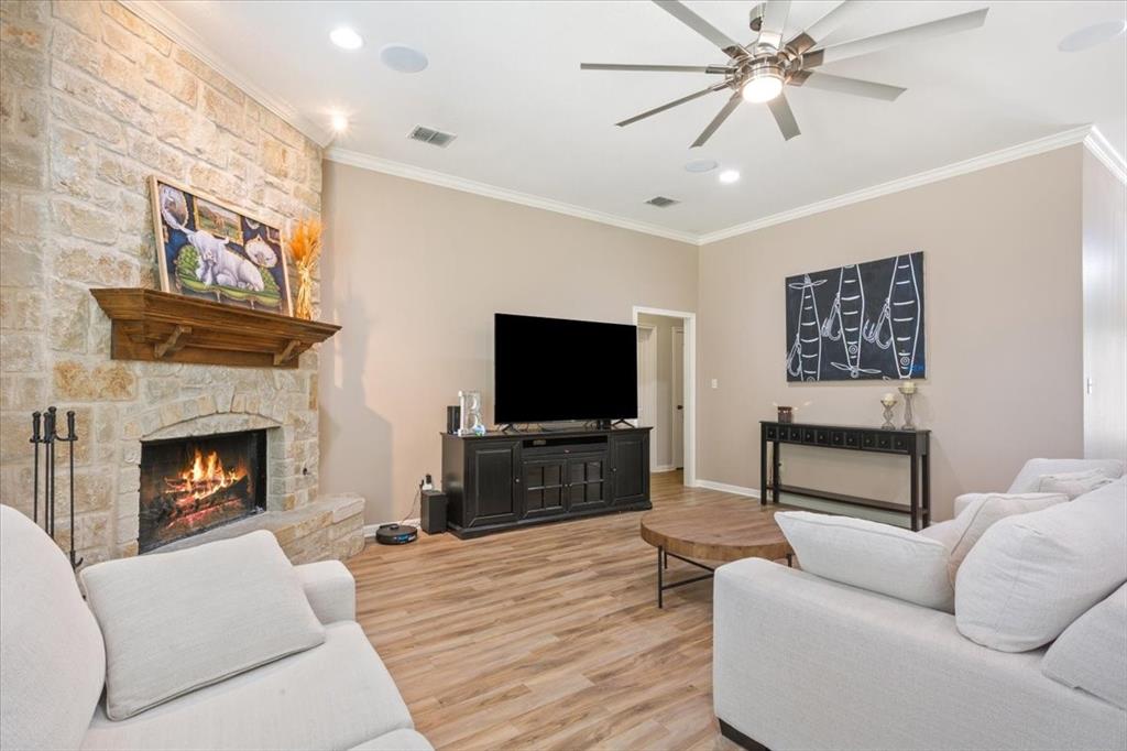 203 Silver Spur Trail Waco, TX 76657 - Photo 6 of 39 Living area with ornamental molding, a stone fireplace, light wood finished floors, recessed lighting, and ceiling fan
