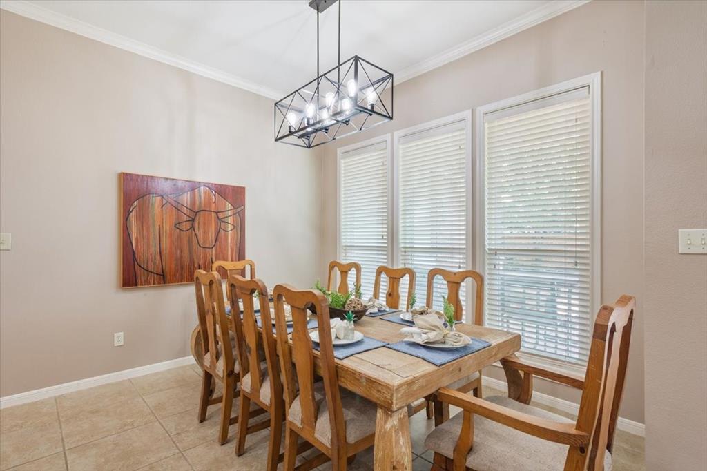203 Silver Spur Trail Waco, TX 76657 - Photo 10 of 39 Dining room featuring crown molding, light tile patterned floors, and a chandelier