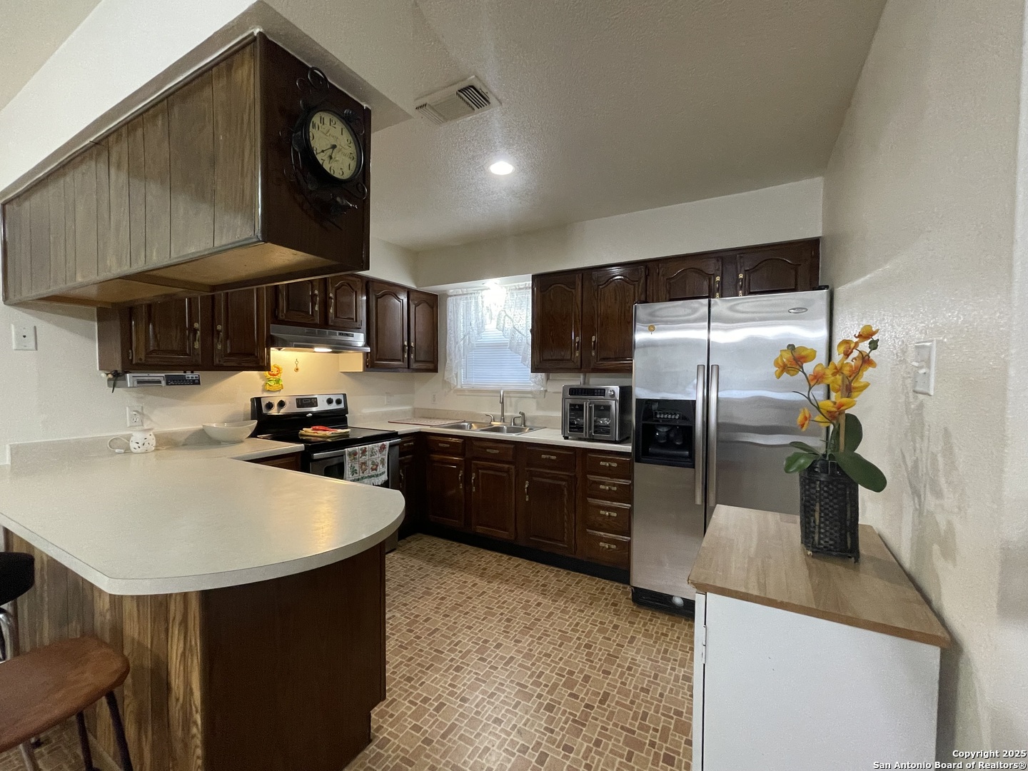 311 3rd Street Christine, TX 78012 - Photo 6 of 10 a kitchen with stainless steel appliances granite countertop a sink a stove and a refrigerator