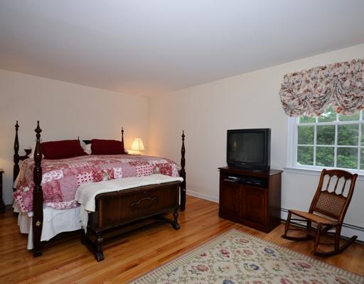 4 Barringer Road Darien, CT 06820 - Photo 11 of 19 a bedroom with a bed a chair and a flat screen tv