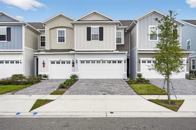 a view of white house with a yard and potted plants