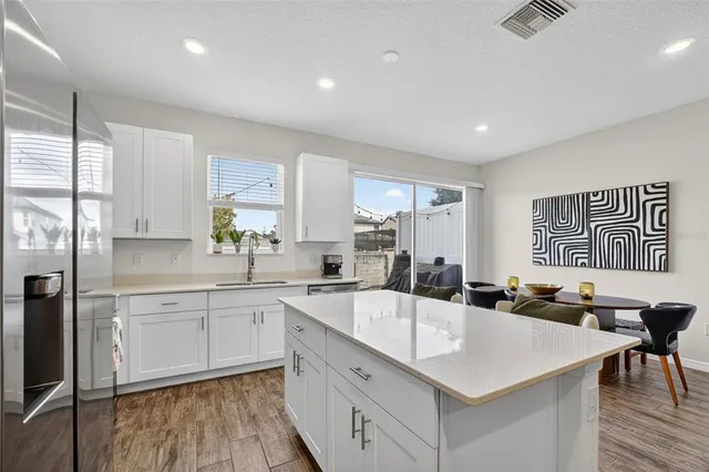 a large kitchen with a large window and stainless steel appliances
