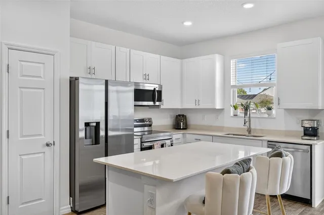 a kitchen with a table chairs stove and kitchen view