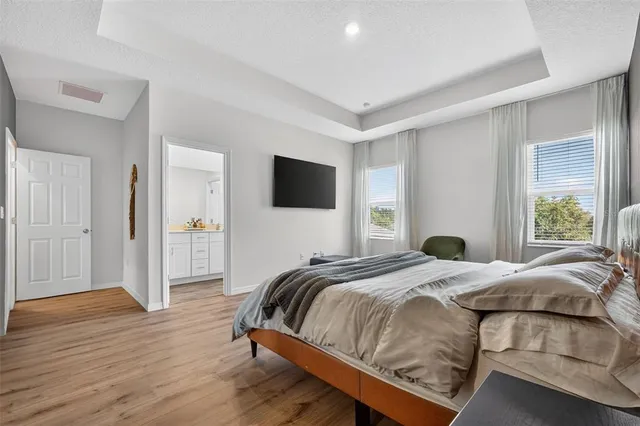 a bedroom with a bed and a flat tv screen on the dresser