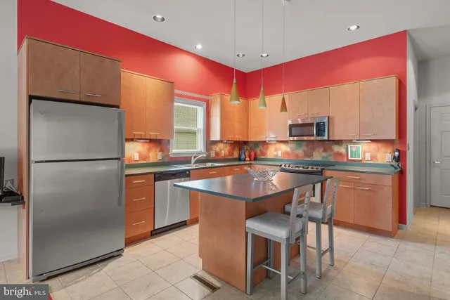 a kitchen with stainless steel appliances granite countertop a sink dishwasher and cabinets with wooden floor