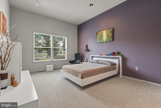 a bedroom with a bed and a large window