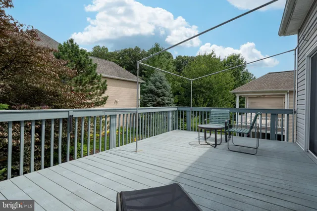 a view of a patio with dining table and chairs with wooden floor and fence