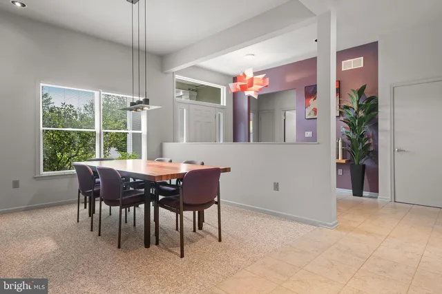 a kitchen with a sink a refrigerator and chairs