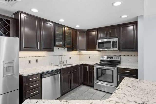 a kitchen with stainless steel appliances granite countertop a sink stove and refrigerator