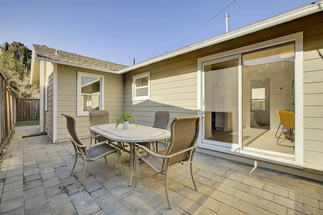 a backyard of a house with table and chairs