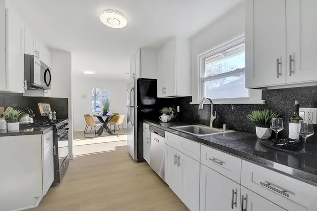 a kitchen with white cabinets and stainless steel appliances