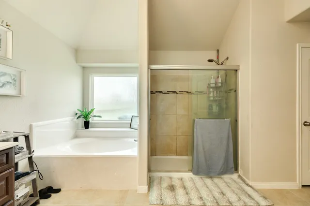 a bathroom with a tub shower and sink
