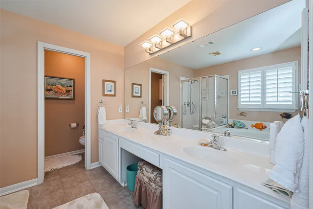 a bathroom with a sink double vanity granite and a mirror