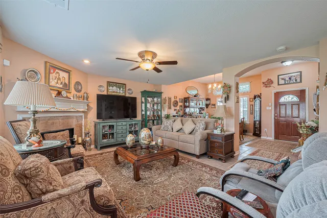 a living room with furniture ceiling fan and a fireplace