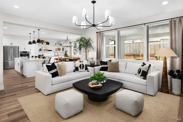 a living room with furniture chandelier and a large window