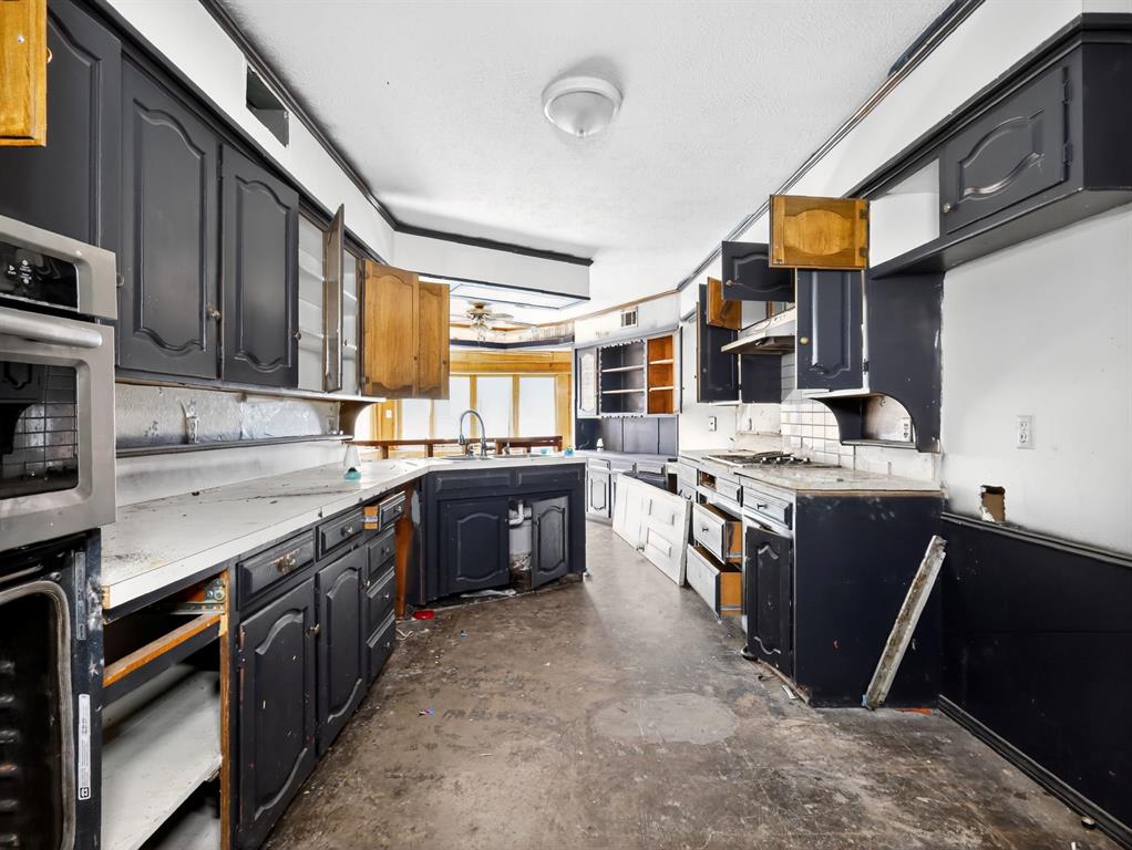 3216 Rotan Lane Dallas, TX 75229 - Photo 13 of 28 a kitchen with stainless steel appliances granite countertop a stove a sink dishwasher and a refrigerator