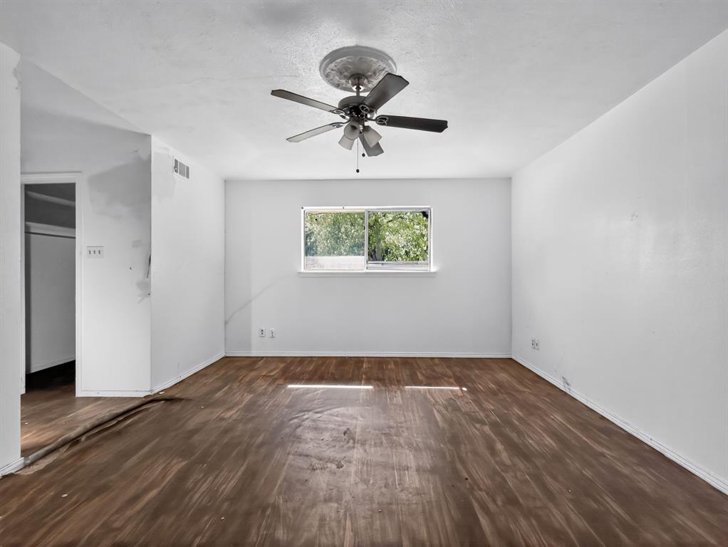 3216 Rotan Lane Dallas, TX 75229 - Photo 19 of 28 a view of empty room with wooden floor and fan
