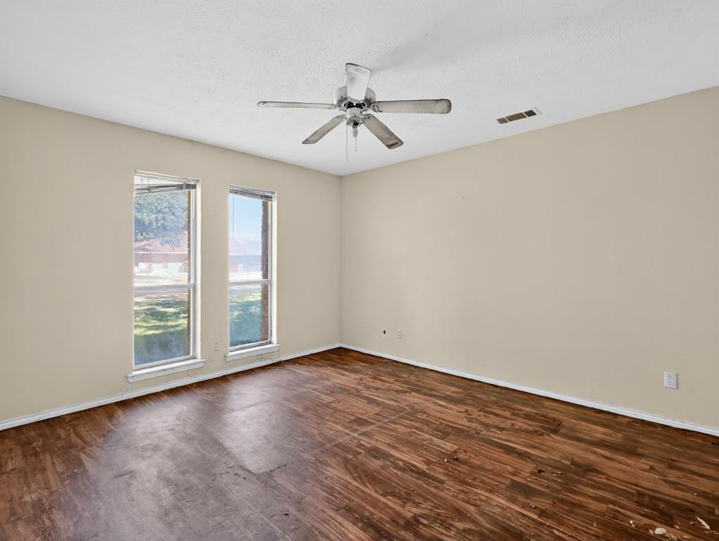 3216 Rotan Lane Dallas, TX 75229 - Photo 9 of 28 an empty room with wooden floor fan and windows