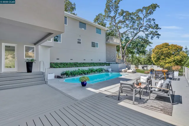 a view of a roof deck with table and chairs with wooden floor and fence
