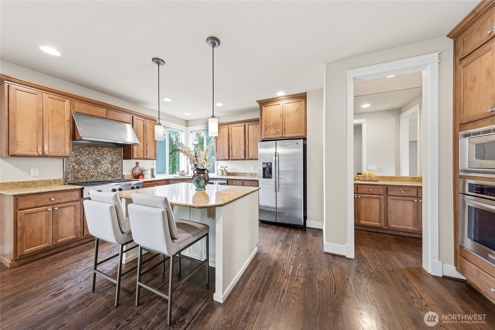 3514 184th Place Southeast Bothell, WA 98012 - Photo 11 of 39 a kitchen with stainless steel appliances kitchen island granite countertop a sink a stove a refrigerator and island with wooden floor