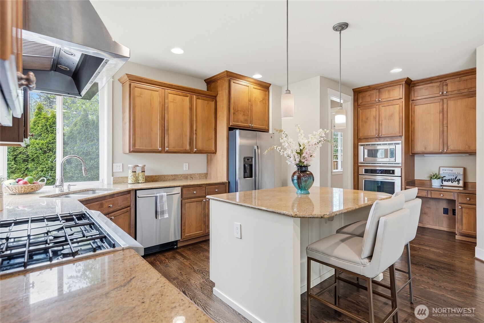 3514 184th Place Southeast Bothell, WA 98012 - Photo 12 of 39 a kitchen with stainless steel appliances granite countertop a stove a sink dishwasher a dining table and chairs with wooden floor