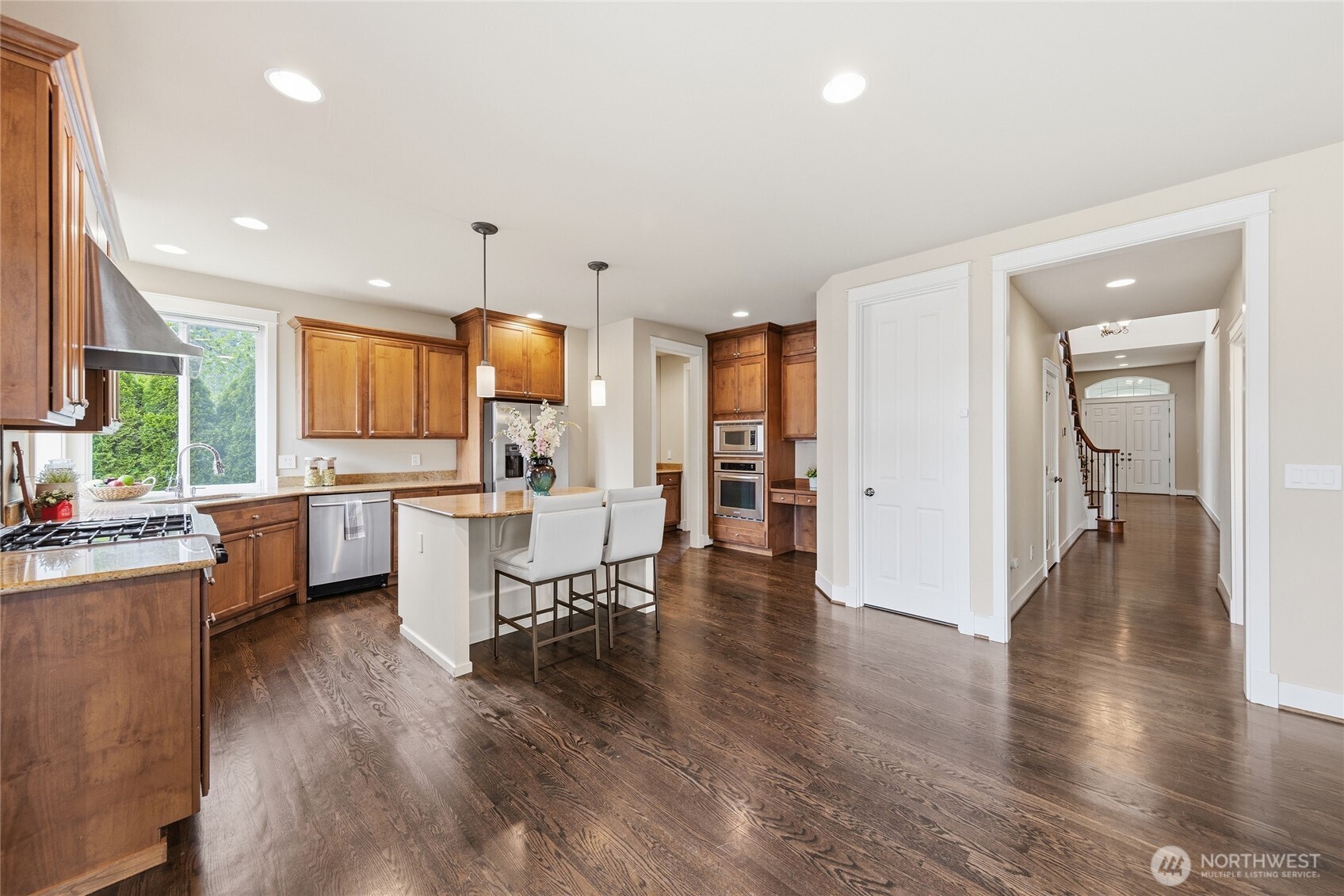 3514 184th Place Southeast Bothell, WA 98012 - Photo 13 of 39 a kitchen with stainless steel appliances kitchen island granite countertop a refrigerator a sink a stove and white cabinets with wooden floor