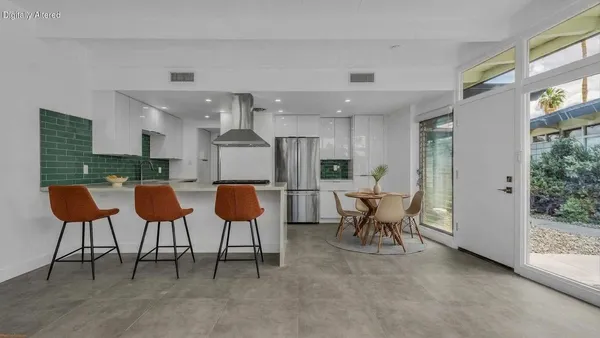 a kitchen with stainless steel appliances kitchen island granite countertop a table and chairs in it