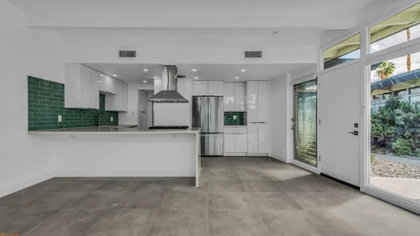 a view of a kitchen with refrigerator and white cabinets