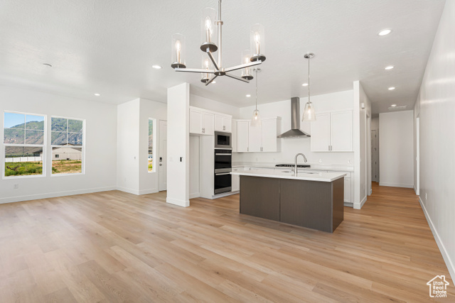 549 North Legend Circle, Unit C/466 Mapleton, UT 84664 - Photo 12 of 39 Kitchen with light countertops, a chandelier, light wood-type flooring, white cabinets, and wall chimney range hood