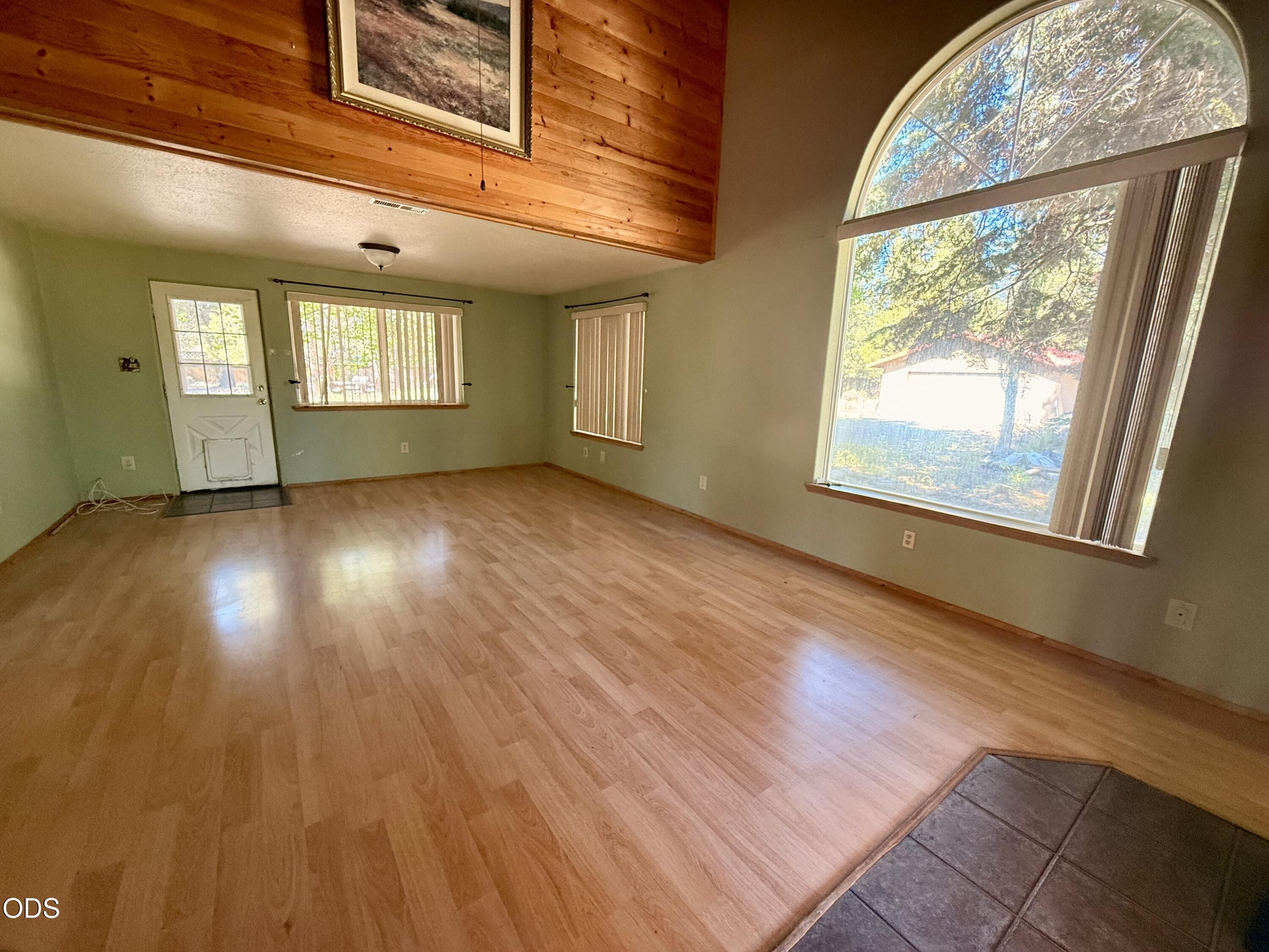 16025 Strawn Road La Pine, OR 97739 - Photo 9 of 95 an empty room with wooden floor and windows
