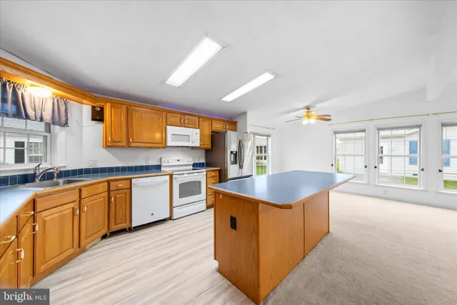 a kitchen with stainless steel appliances granite countertop a sink a stove and a wooden floors