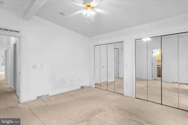 an empty room with fan and entryway
