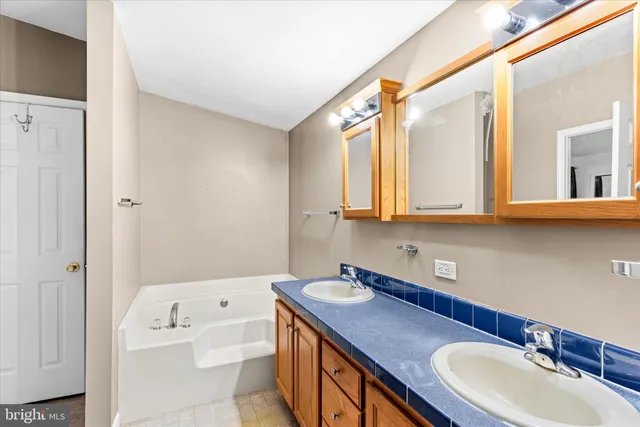 a bathroom with a granite countertop sink toilet a mirror and tub