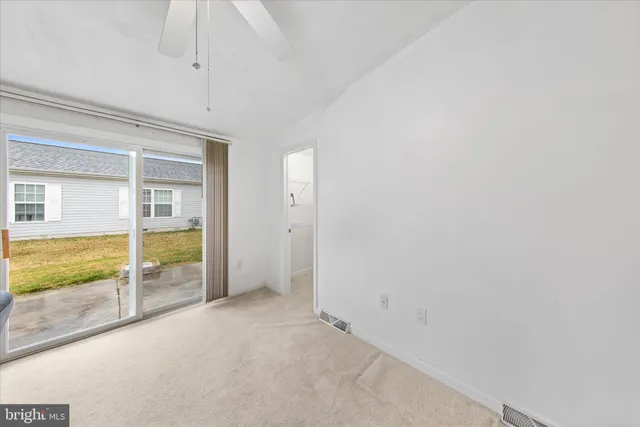 an empty room with sliding door and wooden floor