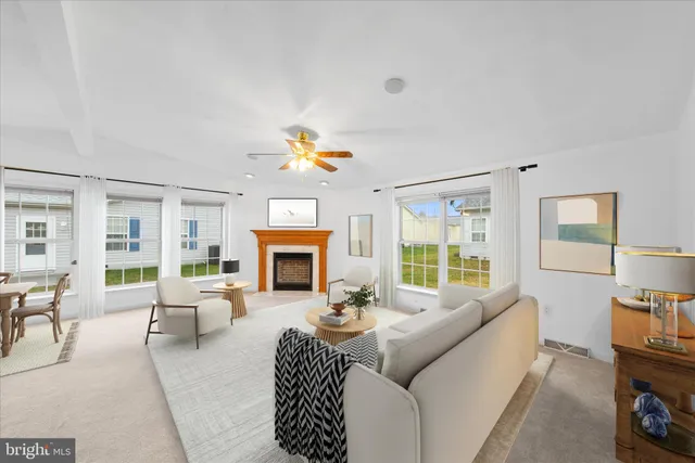 a living room with furniture a fireplace and a floor to ceiling window